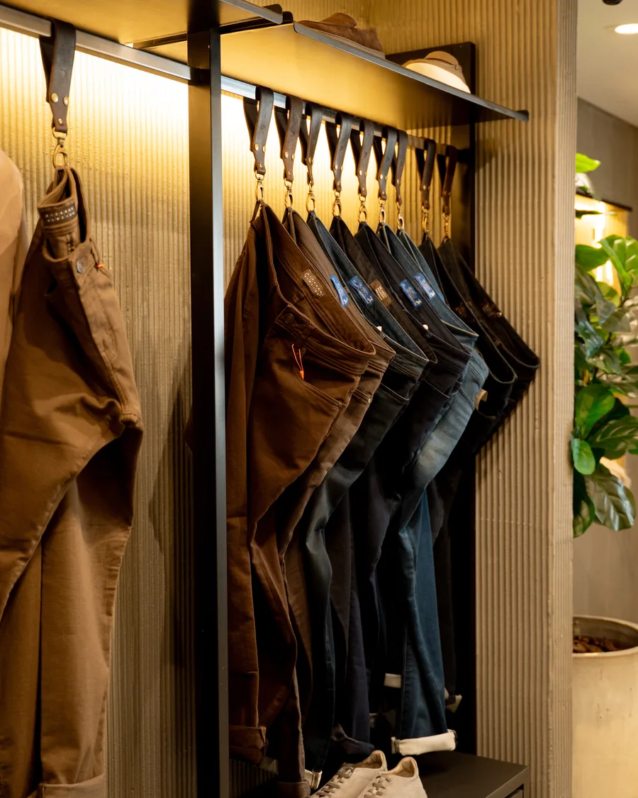 Arara de calças e jeans sob luz quente
